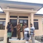 Sekretaris Dinas Perumahan, Kawasan Pemukiman dan Pertanahan, Suharso saat menyerahkan kunci RLH kepada penerima manfaat disaksikan anggota DPRD, Ancelina Beanal di lokasi Belakang Bobaigo Keuskupan Timika